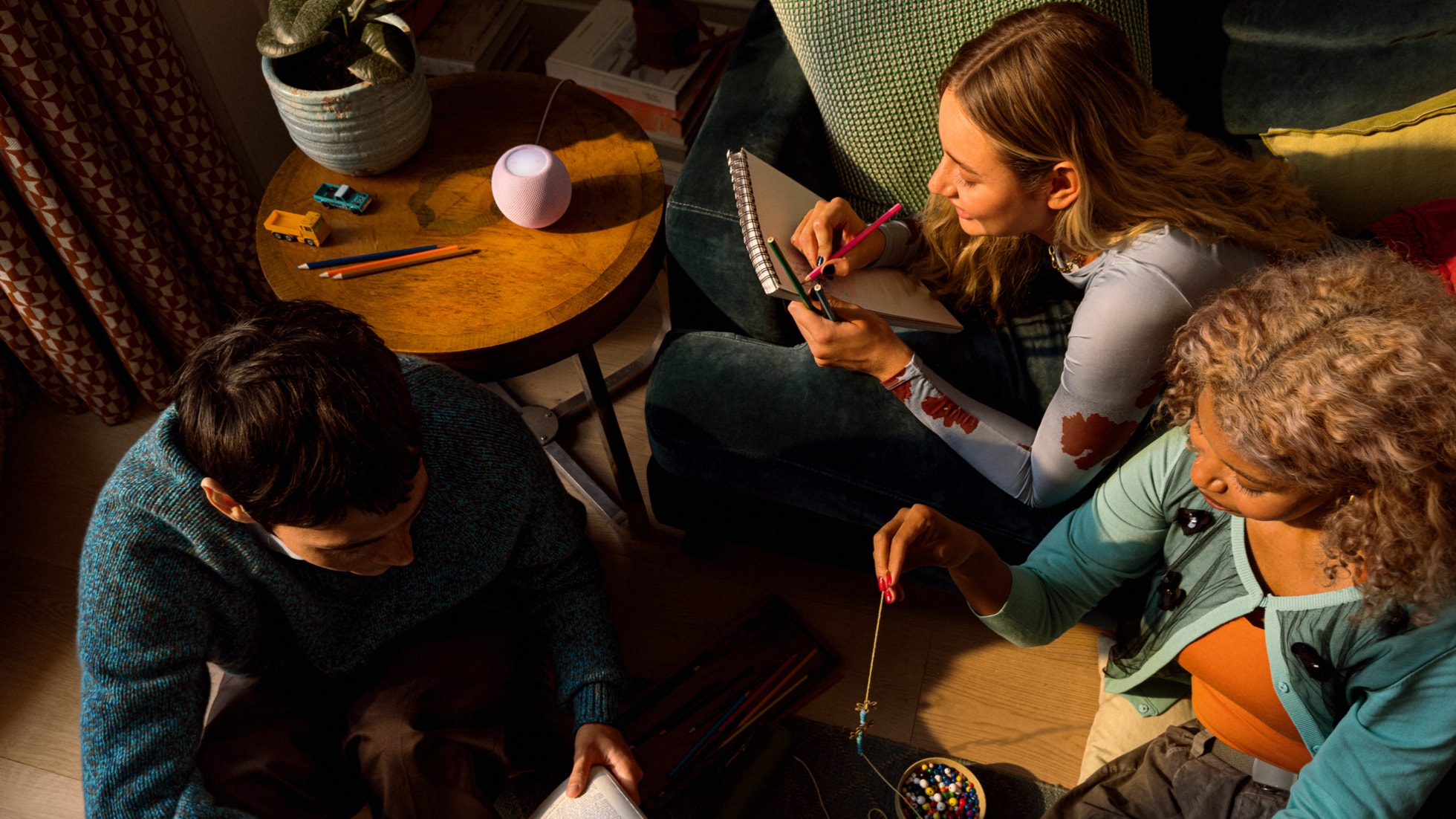A group relaxes with HomePod mini 2 in the background. — Picture from apple.com