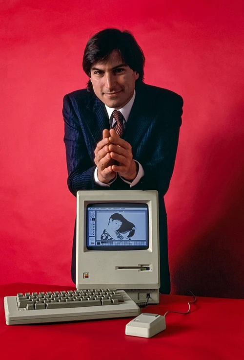Steve Jobs in 1984 with the Macintosh , the first successful mass-market personal computer to feature an integral graphical user interface and mouse — Picture from en.wikipedia.org